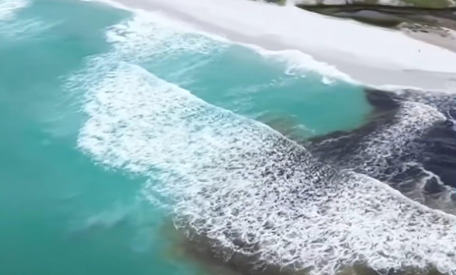 Imagens aéreas mostram a mistura das águas da lagoa e do oceano Reprodução/ Casal nos Clicks