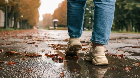 A close up of a woman's feet walking through the rain